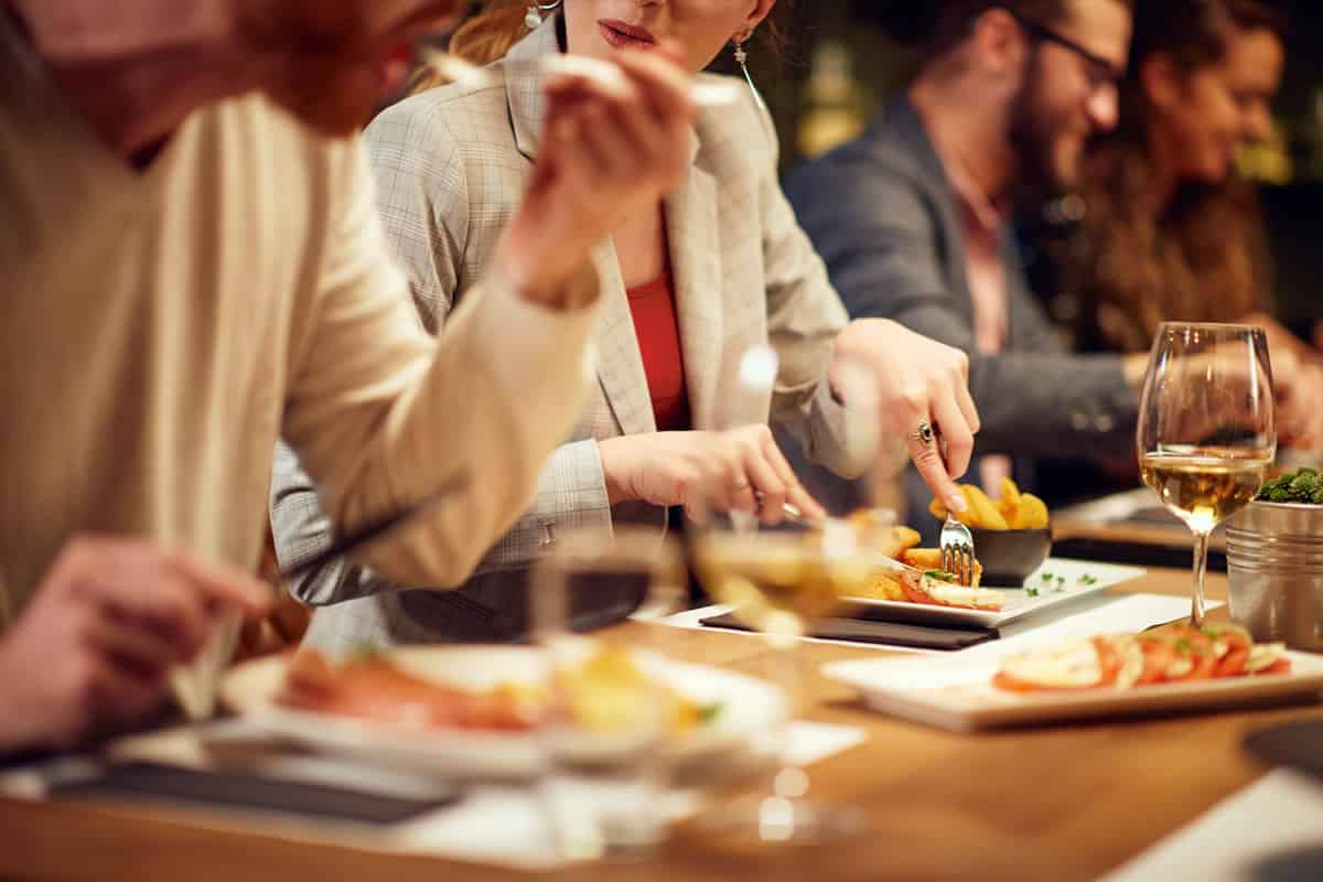 Una descripción optimizada para SEO para restaurantes que presenta a un grupo de personas disfrutando de una comida.